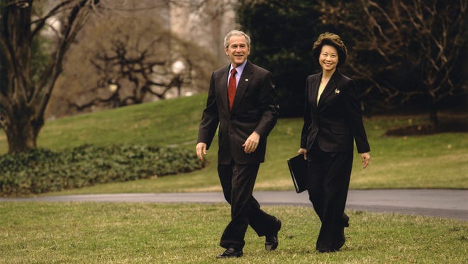 Chao, then the Labor secretary, walks with then-president George W. Bush across the White House South Lawn to board Marine One.