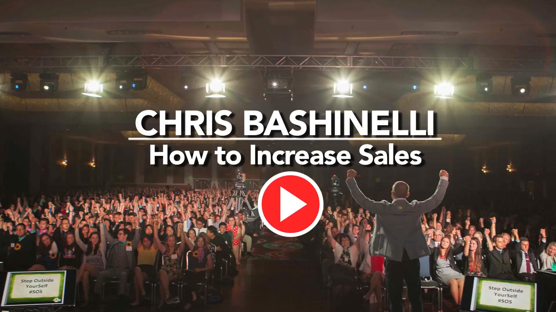 Speaker stands on a stage addressing a large audience; overlay reads 'CHRIS BASHINELLI How to Increase Sales' with a red play button in front.