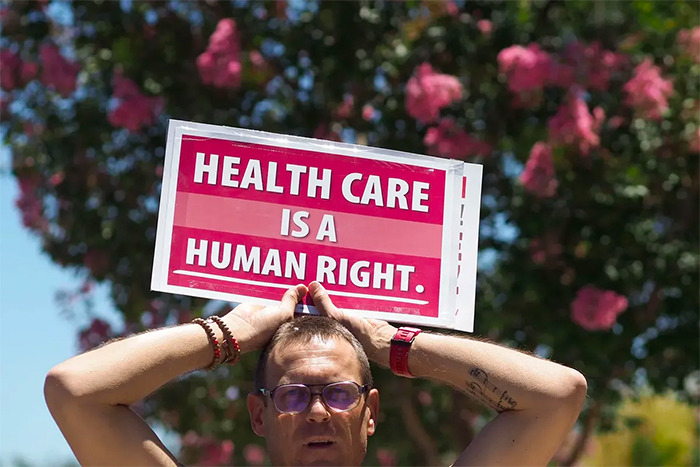 Healthcare Is A Human Right sign for Article by Dave A Chokshi on Health Care