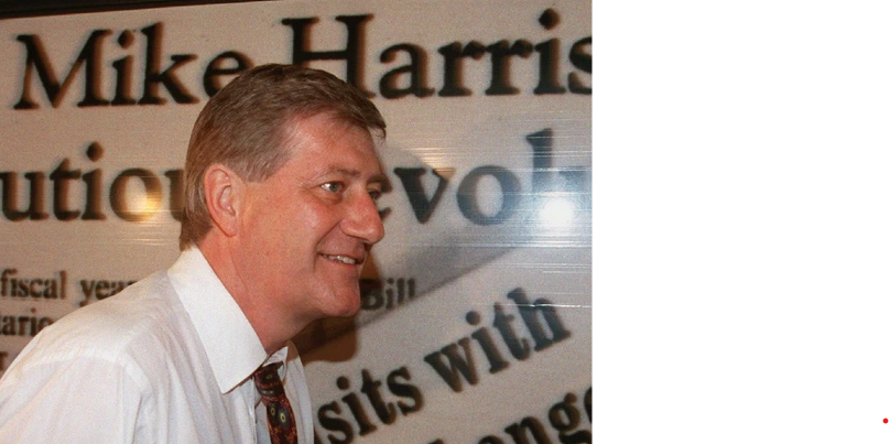 Mike Harris walks past billboard on the side of his campaign bus