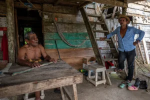 Olegario Hernandez, left, and his neighbor in the village of Limon are facing relocation