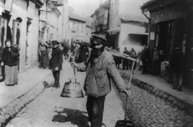 A Jewish water carrier stands in Vilnius in 1922.