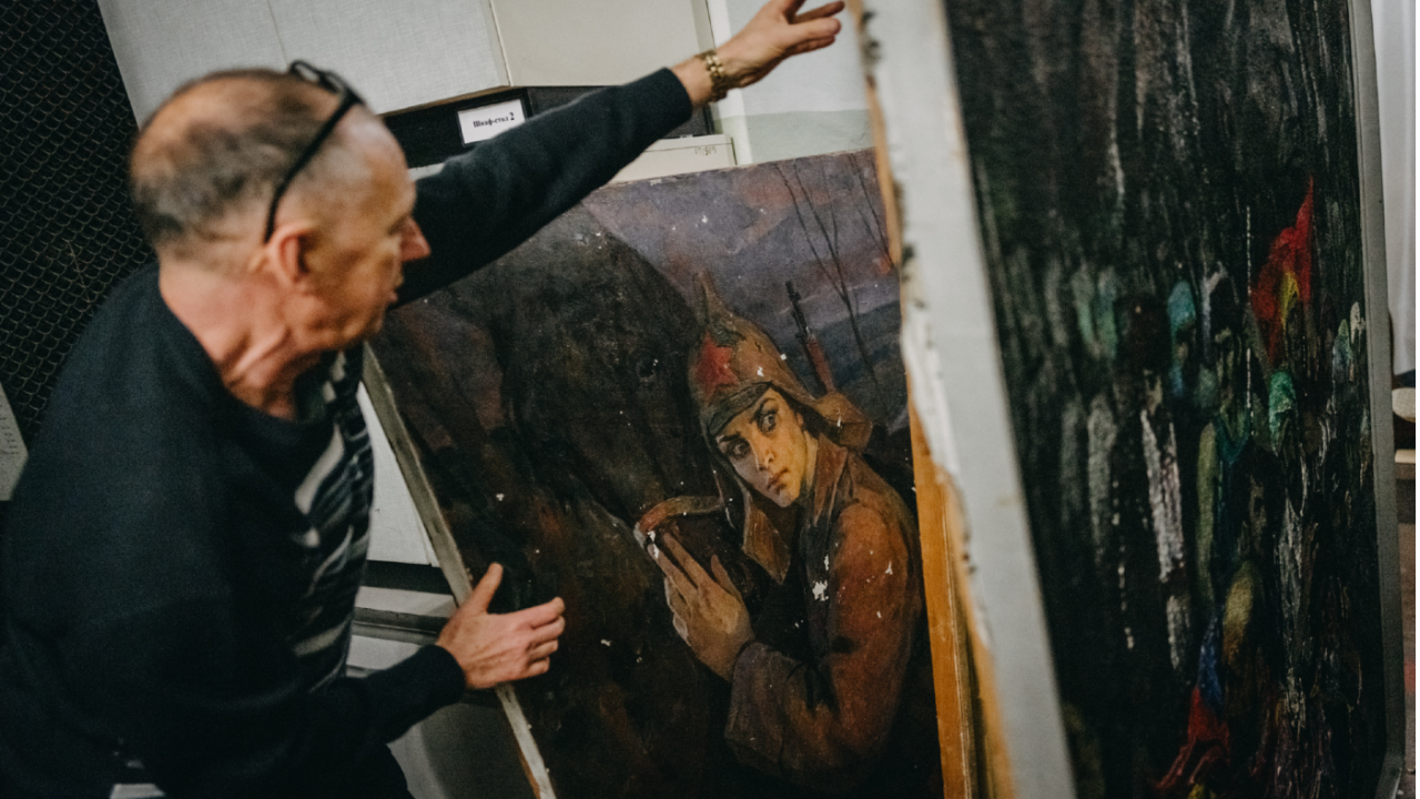 A worker shows the robbed treasury, a few pieces of post-Soviet art including Stalin, Lenin and Red Army, left by Russia in the Art Museum, Kherson, Ukraine. (Photo by Wojciech Grzedzinski/Anadolu via Getty Images)