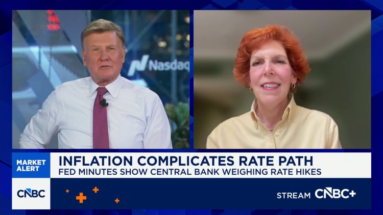 Split-screen of CNBC anchors: left is a man in a white shirt and red tie, right is a woman with orange hair; bottom banner reads 'Inflation Complicates Rate Path' with CNBC branding.