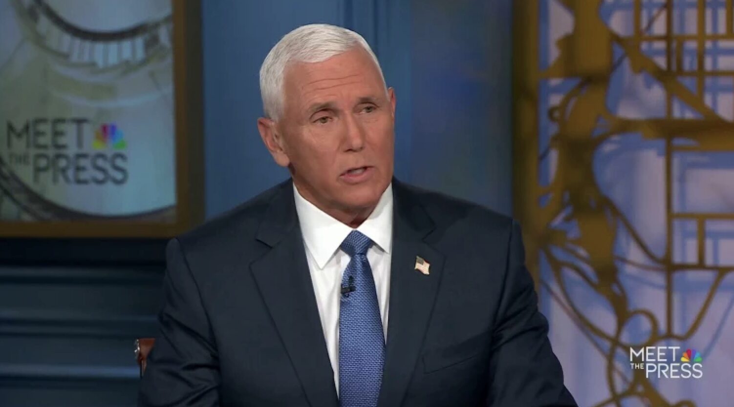 Man in a navy suit and blue tie speaks during a Meet the Press studio interview.