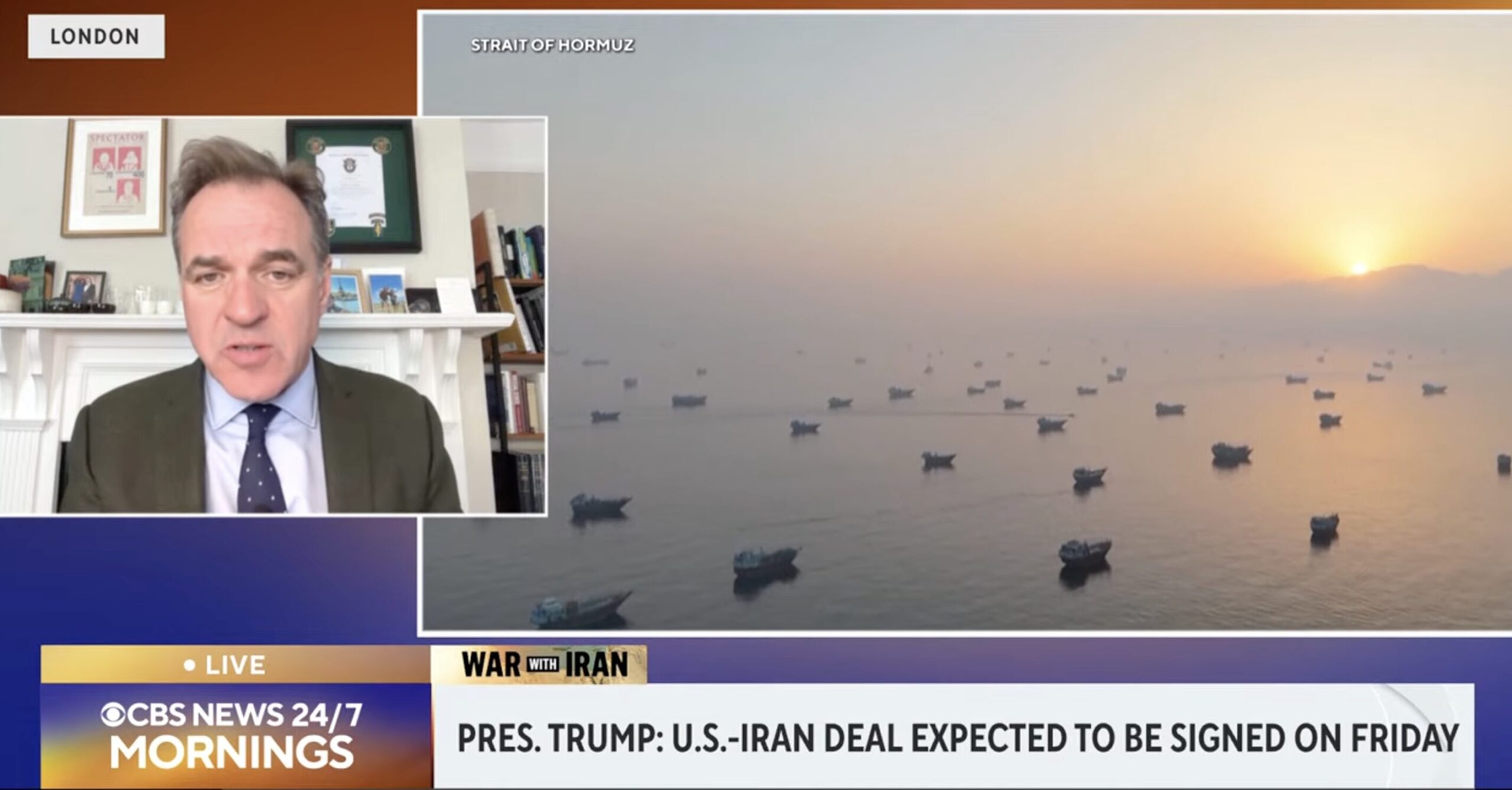Live CBS News morning segment: man in a suit speaks from a home office on the left, with a sunset harbor and boats on the right.