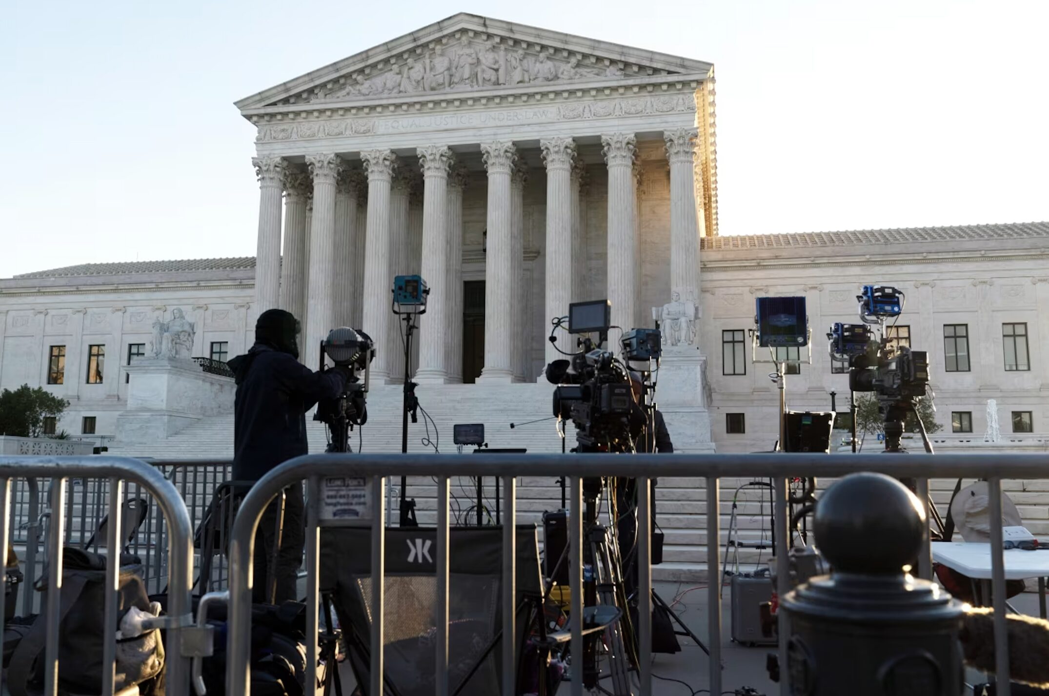 TV news crew setting up cameras and lights outside the U.S. Supreme Court building.
