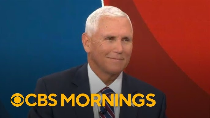 Male news anchor in a dark suit and tie on a CBS Mornings set with a blue and red background.