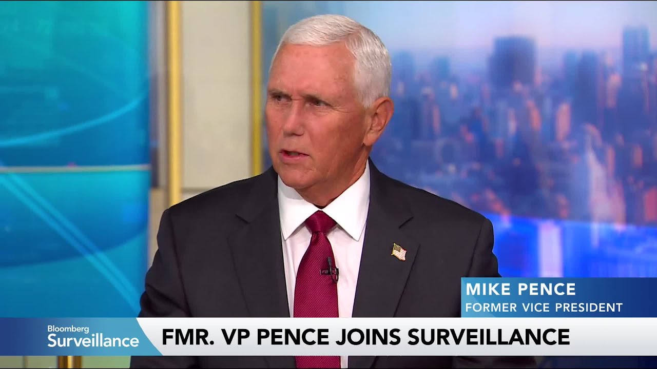 Mike Pence, former Vice President, in a dark suit and red tie speaking on Bloomberg Surveillance set with a city backdrop and lower-third text reading ‘MIKE PENCE FORMER VICE PRESIDENT’ and ‘FMR. VP PENCE JOINS SURVEILLANCE’.