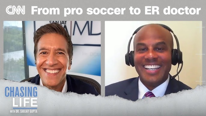 Split-screen interview on CNN's 'Chasing Life' with Dr. Sanjay Gupta; left: smiling host in studio, right: guest wearing a headset and suit; banner reads 'From pro soccer to ER doctor'.