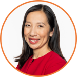 Dr Leana Wen photo_Circ - Worldwide Speakers Group Professional headshot of a smiling woman with dark hair wearing a red blouse, framed by an orange circular border.